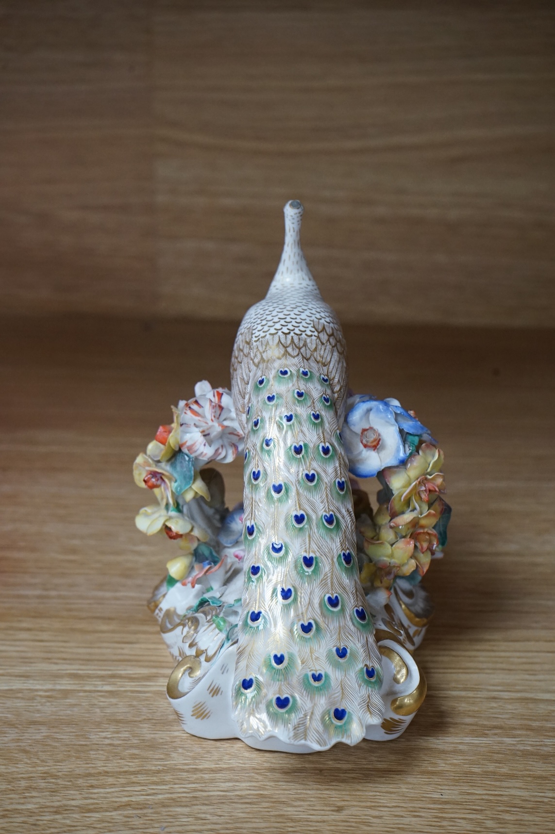 An ornate Bloor Derby peacock with floral encrusted decoration, 16cm high